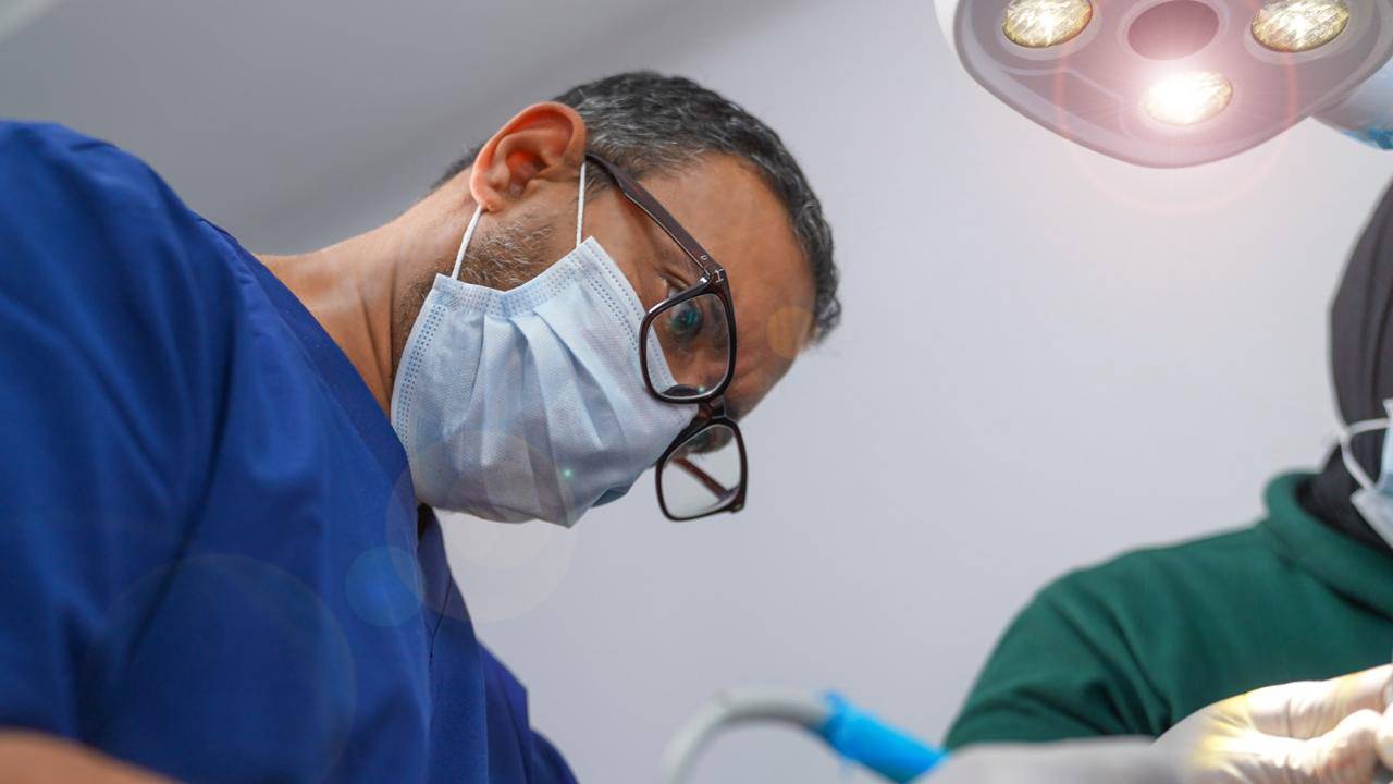 Dr. Ahmed Atteya performing procedure in operating room at Elite Smile Clinics New Cairo